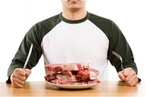 man with raw steaks